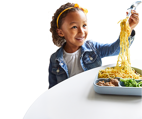 Child happily eating noodles