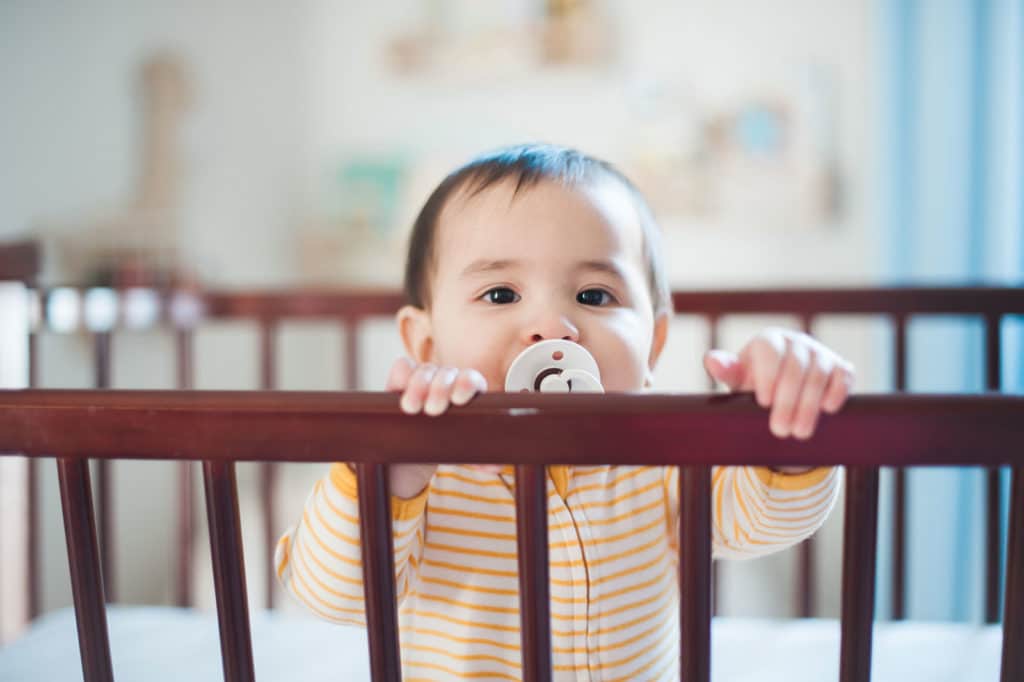 baby peeking over crib